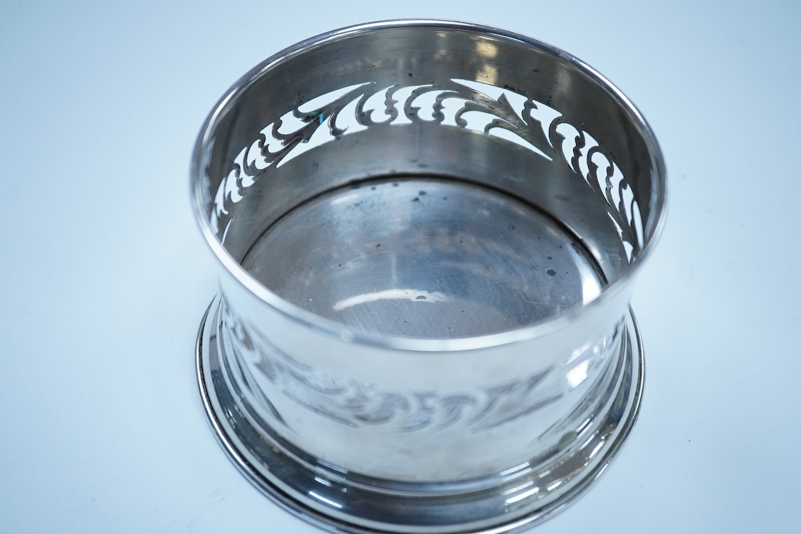 A North America sterling two branch, three branch candelabrum, by Frank M. Whiting & Co, height 15.4cm, weighted, together with a pierced 900 standard white metal bottle coaster, 5.4oz.